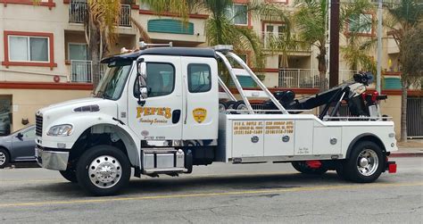 A tow - Available Colors. A wrecker tow truck is a tow truck that hoists two wheels of the tow-vehicle into the air, then drags it behind the tow truck. Two wheels of the tow-vehicle roll on the road while transporting. A wrecker tow truck may also be outfitted with locking bins and storage areas for tools and equipment. 